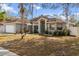 Gray house with teal front door and landscaped yard at 5574 Sweetwater Oak, Sarasota, FL 34232