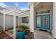 Front entryway with teal door and white pergola at 5574 Sweetwater Oak, Sarasota, FL 34232