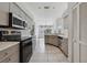 Modern kitchen with curved island, wood cabinets, and stainless steel appliances at 5574 Sweetwater Oak, Sarasota, FL 34232