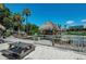 Relaxing waterfront view with a thatched roof hut and picnic tables at 5612 Ashton Lake Dr # 5612, Sarasota, FL 34231