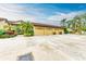 Three-car garage with light yellow doors and landscaping at 5612 Ashton Lake Dr # 5612, Sarasota, FL 34231