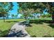 Park with a paved pathway, lush grass, and a bench under shade trees at 5612 Ashton Lake Dr # 5612, Sarasota, FL 34231