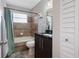 Bathroom with tub, toilet and dark vanity at 5640 Westwind Ln, Sarasota, FL 34231