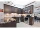 Modern kitchen with dark brown cabinets, granite counters, and stainless steel appliances at 5640 Westwind Ln, Sarasota, FL 34231