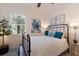 Guest bedroom with metal bed frame, coastal wall art, and window with plantation shutters at 579 Fore Dr, Bradenton, FL 34208