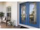 Blue double front doors with glass insets and a wooden bench at 579 Fore Dr, Bradenton, FL 34208