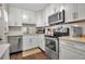 Modern kitchen with white cabinets, stainless steel appliances and a view into dining area at 6115 Twig Cir # 6D, Bradenton, FL 34209