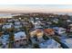 Aerial view of tropical waterfront homes, surrounded by canals and lush greenery with a beautiful golden sunset sky at 614 Norton St, Longboat Key, FL 34228