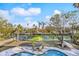 Aerial shot of the pool and canal view, showcasing the manicured lawn, patio furniture, and lush tropical surroundings at 614 Norton St, Longboat Key, FL 34228