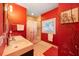 Bathroom with dual sinks, a shower-tub combination, and bright red walls at 614 Norton St, Longboat Key, FL 34228