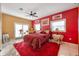 Cozy bedroom featuring a plush rug, vibrant red walls, and ample natural light at 614 Norton St, Longboat Key, FL 34228