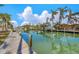 Beautiful canal view with private dock, boats, and palm trees under a blue, sunny sky at 614 Norton St, Longboat Key, FL 34228