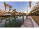 Canal view featuring private dock, lush palms, and boats with clear reflection at dusk at 614 Norton St, Longboat Key, FL 34228