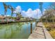 Waterfront home with private boat dock, palm trees, and blue sky with white clouds at 614 Norton St, Longboat Key, FL 34228