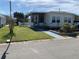 Landscaped yard with walkway leading to a manufactured home at 712 51St Avenue W Ter, Bradenton, FL 34207