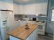 Bright kitchen with white cabinets, butcher block island, and modern appliances at 712 51St Avenue W Ter, Bradenton, FL 34207