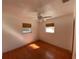 Simple bedroom with hardwood floors and two windows at 7307 9Th Nw Ave, Bradenton, FL 34209