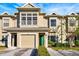 Tan two-story townhome with green door, two-car garage, and landscaping at 7560 Plantation Cir, Bradenton, FL 34201