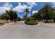 Gated entrance to a community with palm trees and landscaping at 8240 Parkside Dr, Englewood, FL 34224