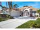 Tan house with white trim, two-car garage, and landscaped yard at 8240 Parkside Dr, Englewood, FL 34224