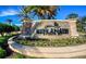 An elegant stone entrance sign surrounded by lush tropical landscaping at the Esplanade at 8279 Varenna Dr, Sarasota, FL 34231