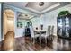 Elegant dining room with modern lighting, mirrored accent wall, and hardwood flooring at 8279 Varenna Dr, Sarasota, FL 34231