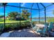 Screened-in patio with a table and chairs offering scenic views of the lawn and lake at 8279 Varenna Dr, Sarasota, FL 34231