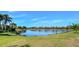 Scenic pond view surrounded by lush greenery, mature trees and well-maintained lawns at 8279 Varenna Dr, Sarasota, FL 34231