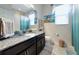 Full bathroom with granite vanity, decorative mirror, and a shower behind a blue-tinted curtain at 854 Rosemary Cir, Bradenton, FL 34212