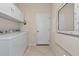 Bright laundry room featuring white cabinets, washer and dryer, and an updated tile floor at 854 Rosemary Cir, Bradenton, FL 34212