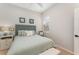 Guest bedroom with light green bedding, white nightstand, and window with blinds at 108 Savona Ct, North Venice, FL 34275