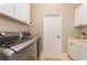 Laundry room with modern washer and dryer, white cabinets, and a utility sink at 108 Savona Ct, North Venice, FL 34275