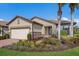 One-story home with a two-car garage, neatly landscaped yard, and palm trees at 11136 Shearwater Ct, Sarasota, FL 34238