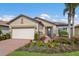 Single-story home with a two-car garage, landscaped yard, and brick paver driveway at 11136 Shearwater Ct, Sarasota, FL 34238