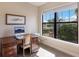 Bright home office features a large window, hardwood desk and comfortable chair at 11136 Shearwater Ct, Sarasota, FL 34238