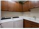 Laundry room with Whirlpool washer and dryer and ample cabinetry at 11136 Shearwater Ct, Sarasota, FL 34238