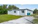 Newly constructed home showcasing a gray exterior, green lawn, and a spacious driveway at 1226 Coral Ridge Dr, Punta Gorda, FL 33950