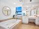 Spa-like bathroom with a large soaking tub and walk-in shower at 1281 Gulf Of Mexico Dr # 404, Longboat Key, FL 34228