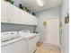 Bright laundry room features white cabinets, washer, dryer, and sink at 12904 49Th E Ln, Parrish, FL 34219