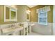 Elegant bathroom with double sinks, pedestal vanities, and white tile at 13616 Legends Walk Ter, Lakewood Ranch, FL 34202