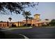 Elegant clubhouse exterior at dusk, featuring palm trees and landscaping at 13616 Legends Walk Ter, Lakewood Ranch, FL 34202