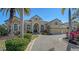 Tan house with palm trees and a large driveway at 13616 Legends Walk Ter, Lakewood Ranch, FL 34202