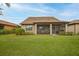 Home's backyard with screened patio and grass at 13925 Miranese St, Venice, FL 34293