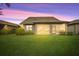 Home with screened lanai and grassy backyard at sunset at 13925 Miranese St, Venice, FL 34293