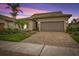 Single-story home with brown garage door and landscaped front yard at 13925 Miranese St, Venice, FL 34293