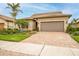 Single-story home with brown garage door and landscaped front yard at 13925 Miranese St, Venice, FL 34293