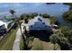 Aerial view of two-story waterfront home, showcasing private dock and landscaping at 145 Burns Rd, Terra Ceia, FL 34250