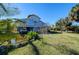 Elevated home with palm trees, grassy yard, and carport at 145 Burns Rd, Terra Ceia, FL 34250