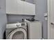 Bright laundry room, featuring washer, dryer, and overhead cabinets at 14802 7Th E Ave, Bradenton, FL 34212