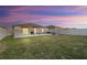 Serene backyard at dusk, featuring a patio and grassy area at 15304 Miller Creek Dr, Sun City Center, FL 33573